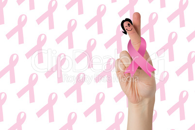 Composite image of crossed fingers with breast cancer ribbon