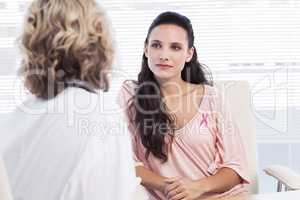Composite image of female patient listening to doctor with conce
