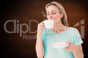Composite image of peaceful blonde drinking hot beverage with ey
