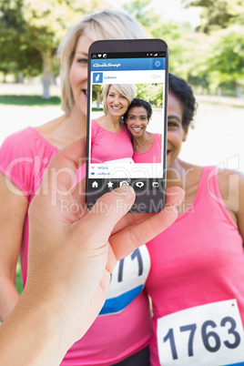 Composite image of female hand holding a smartphone