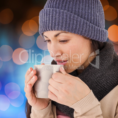 Composite image of smiling brunette drinking hot beverage