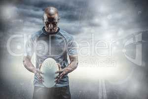 Composite image of thoughtful athlete looking at rugby ball