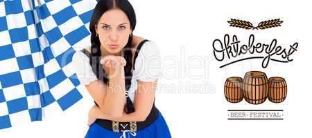 Composite image of pretty oktoberfest girl blowing a kiss