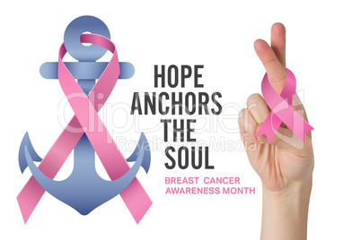 Composite image of crossed fingers with breast cancer ribbon