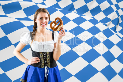 Composite image of pretty oktoberfest girl holding pretzel