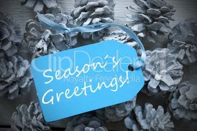 Light Blue Label On Fir Cones With Seasons Greetings