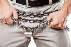 Man hands holding padlock locked chain over pants zip fly