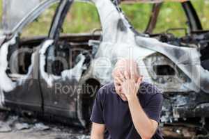 Crying upset man at arson fire burnt car vehicle junk