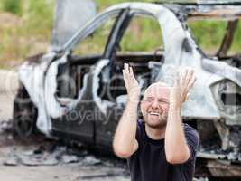 Crying upset man at arson fire burnt car vehicle junk