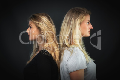 2 blonde Mädchen stehen Rücken an Rücken