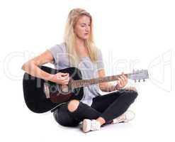 Mädchen im Schneidersitz spielt auf einer Gitarre