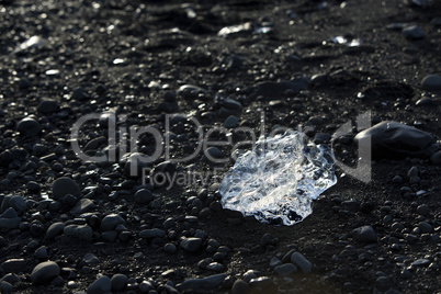 Ice block on black sand beach at glacier lagoon Jokulsarlon, Ice