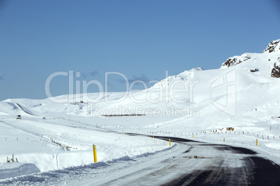 Snowy and slippery road with volcanic mountains in wintertime
