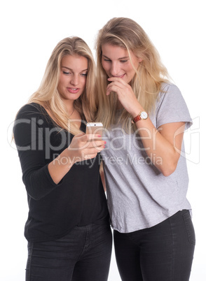 2 Schwestern schauen neugierig auf ein Handy