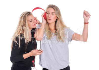 2 Freundinnnen teilen einen Kopfhörer und lauschen der Musik