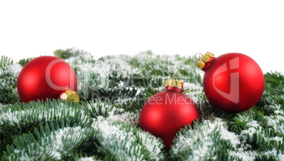 Red Christmas baubles and snow on fir branches