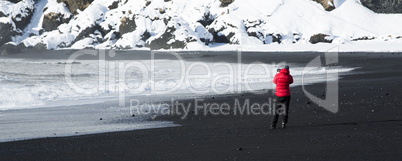 Photographer at the black sand beach in Vik, Iceland