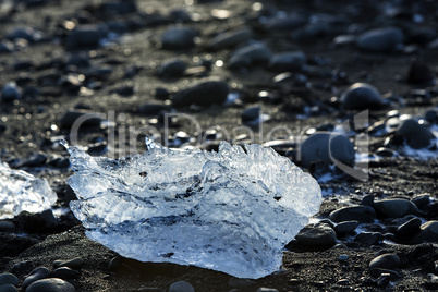 Ice block on black sand beach at glacier lagoon Jokulsarlon, Ice