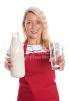 Hausfrau in Schürze präsentiert frische Milch in einer Flasche und einem Glas