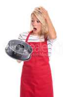 Frau in Schürze hält eine Kuchenform und ist erschrocken