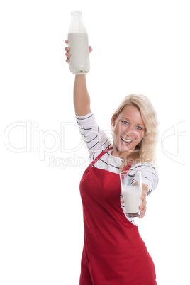 Hausfrau in Schürze präsentiert frische Milch in einer Flasche und einem Glas