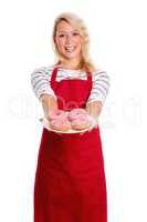 Hausfrau in Schürze hält einen Teller Donuts