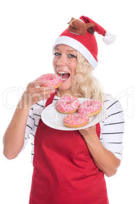 Weihnachtsfrau in Schürze beißt in einen Donut