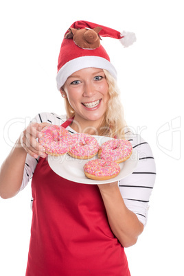 Weihnachtsfrau in Schürze zeigt einen Teller Donuts