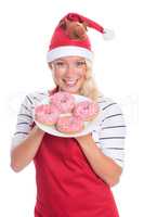Weihnachtsfrau in Schürze zeigt einen Teller Donuts