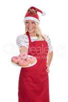 Weihnachtsfrau in Schürze zeigt einen Teller Donuts