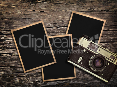 old vintage camera and photos on a wooden background