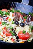 frische Pasta mit Tomaten und Oliven in einer Pfanne