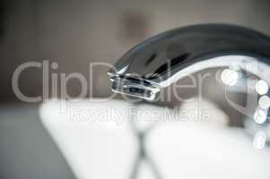Metallic chrome bathroom faucet detail