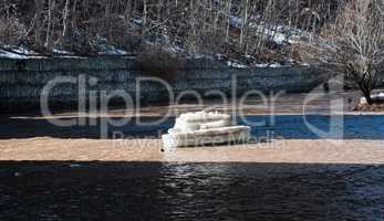 Chunk of ice illuminated in shallow river