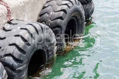 Old black tires used as bumpers at dock