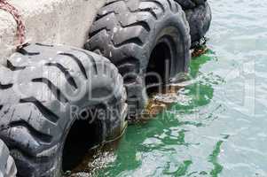 Old black tires used as bumpers at dock