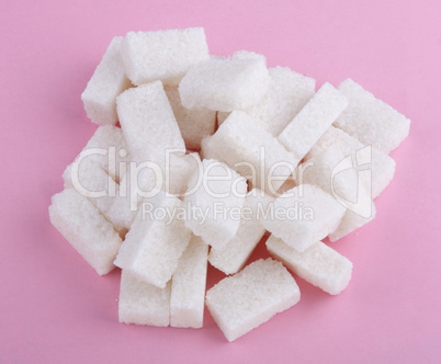 heap of sugar on pink background