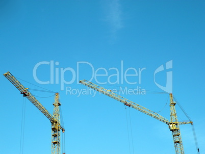 two crane towers on sky background