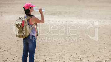 Traveller drinking water from bottle in the desert