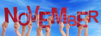 Many People Hands Holding Red Word November Blue Sky