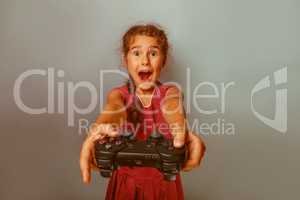 Girl European appearance ten years holding a joystick in his han