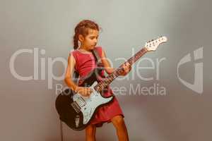 Girl European appearance ten years playing guitar on a blue back