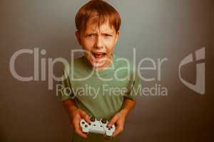 Teen boy screaming open mouth holds emotions game joystick on a