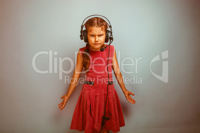 Teen girl child dissatisfied evil in headphones with a microphon