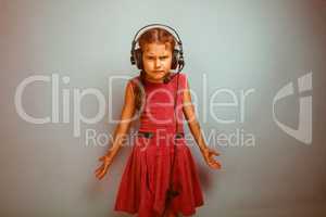 Teen girl child dissatisfied evil in headphones with a microphon