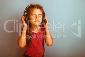 Teen girl child eyes closed listening to music with big headphon