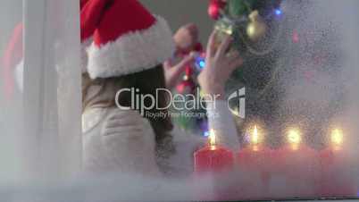 Cute happy children have fun around Christmas tree decorated with balls