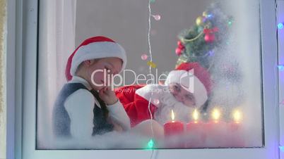 Mother in Santa Claus suit with his little daughter celebrate Christmas