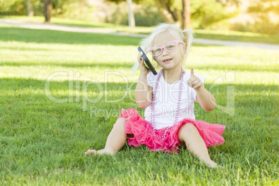 Little Girl In Grass Talking on Cell Phone