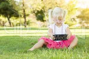 Little Girl In Grass Playing With Cell Phone